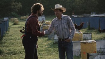 Movie still from “Cockfighter” (1974), directed by Monte Hellman – Two men are talking in a field of grass; Medium shot, Over the shoulder angle