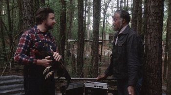 Movie still from “Cockfighter” (1974), directed by Monte Hellman – Two men are talking in the woods while holding guitars; Medium shot, Low angle