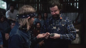 Movie still from “Cockfighter” (1974), directed by Monte Hellman – A man and a woman are looking at a cell phone; Medium shot, Over the shoulder angle