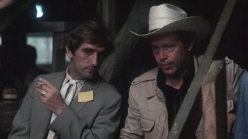 Movie still from “Cockfighter” (1974), directed by Monte Hellman – Two men standing next to each other wearing hats; Close Up shot, High angle