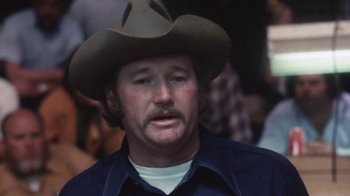 Movie still from “Cockfighter” (1974), directed by Monte Hellman – A person wearing a cowboy hat; Close Up shot, High angle