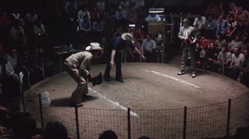 Movie still from “Cockfighter” (1974), directed by Monte Hellman – Two men in cowboy hats are playing a game; Wide shot, High angle