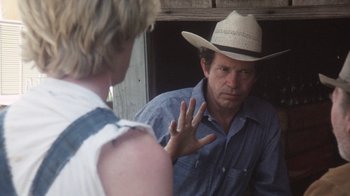 Movie still from “Cockfighter” (1974), directed by Monte Hellman – A man wearing a cowboy hat talking to another man; Close Up shot, Over the shoulder angle