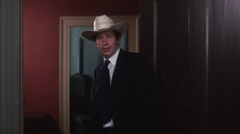 Movie still from “Cockfighter” (1974), directed by Monte Hellman – A man wearing a suit and a hat; Close Up shot, Over the shoulder angle