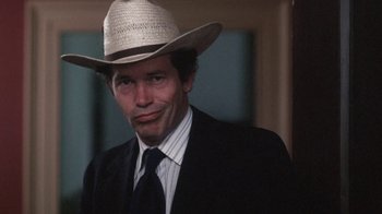 Movie still from “Cockfighter” (1974), directed by Monte Hellman – A man in a suit and a straw cowboy hat; Close Up shot, Low angle