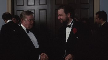 Movie still from “Cockfighter” (1974), directed by Monte Hellman – Two men in tuxedos shaking hands at a formal event; Medium shot, Over the shoulder angle
