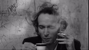 Movie still from “Coffee and Cigarettes” (2003), directed by Jim Jarmusch – A black and white photo of a man smoking a cigarette; Close Up shot, Low angle