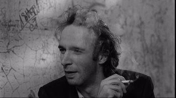 Movie still from “Coffee and Cigarettes” (2003), directed by Jim Jarmusch – A black and white photo of a man smoking a cigarette; Close Up shot, Low angle