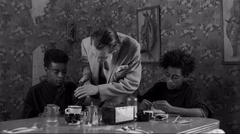 Movie still from “Coffee and Cigarettes” (2003), directed by Jim Jarmusch – A group of young men sitting around a table; Medium shot, Low angle