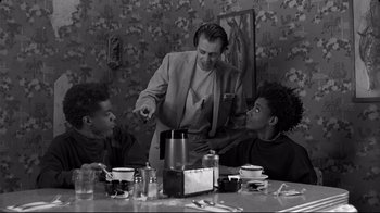 Movie still from “Coffee and Cigarettes” (2003), directed by Jim Jarmusch – A group of people sitting around a table; Medium shot, Low angle