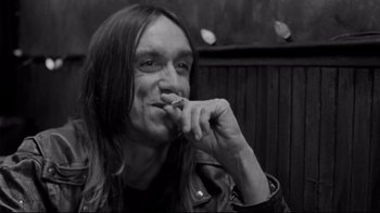 Movie still from “Coffee and Cigarettes” (2003), directed by Jim Jarmusch – Black and white photograph of a man smoking a cigarette; Close Up shot, High angle