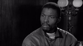 Movie still from “Coffee and Cigarettes” (2003), directed by Jim Jarmusch – A black and white photo of a man in a leather jacket; Close Up shot, Low angle