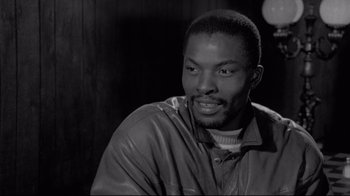 Movie still from “Coffee and Cigarettes” (2003), directed by Jim Jarmusch – A black and white photo of a man in a leather jacket; Close Up shot, Low angle