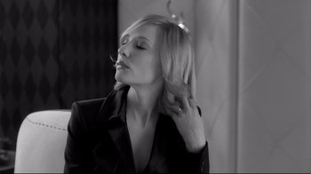 Movie still from “Coffee and Cigarettes” (2003), directed by Jim Jarmusch – A black - and - white photo of a woman in a suit; Close Up shot, Over the shoulder angle