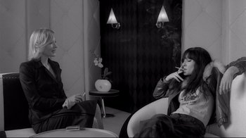 Movie still from “Coffee and Cigarettes” (2003), directed by Jim Jarmusch – Two people are sitting in a room smoking; Medium shot, Over the shoulder angle