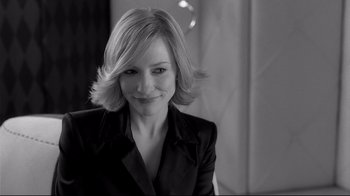 Movie still from “Coffee and Cigarettes” (2003), directed by Jim Jarmusch – Black and white photograph of a woman smiling for the camera; Close Up shot, Over the shoulder angle