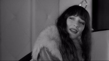 Movie still from “Coffee and Cigarettes” (2003), directed by Jim Jarmusch – A black - and - white photo of a woman wearing a fur coat; Close Up shot, High angle