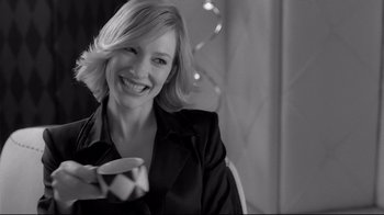 Movie still from “Coffee and Cigarettes” (2003), directed by Jim Jarmusch – A woman smiling while holding a cup of coffee; Close Up shot, Over the shoulder angle