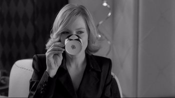 Movie still from “Coffee and Cigarettes” (2003), directed by Jim Jarmusch – A woman holding a coffee cup up to her face; Close Up shot, Over the shoulder angle