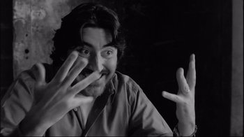 Movie still from “Coffee and Cigarettes” (2003), directed by Jim Jarmusch – A black and white photo of a man making a funny face; Close Up shot, Low angle