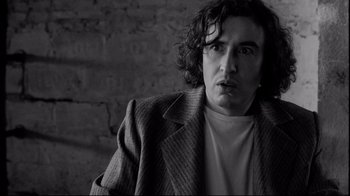 Movie still from “Coffee and Cigarettes” (2003), directed by Jim Jarmusch – Black and white photograph of a man in a jacket; Close Up shot, Low angle