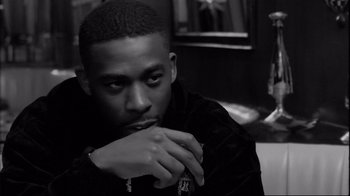 Movie still from “Coffee and Cigarettes” (2003), directed by Jim Jarmusch – A black and white photo of a man with his hand on his chin; Close Up shot, Over the shoulder angle