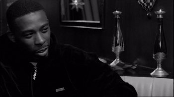 Movie still from “Coffee and Cigarettes” (2003), directed by Jim Jarmusch – A black and white photo of a man smiling; Close Up shot, Over the shoulder angle