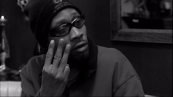 Movie still from “Coffee and Cigarettes” (2003), directed by Jim Jarmusch – A black and white photo of a man with his hand up to his face; Close Up shot, High angle