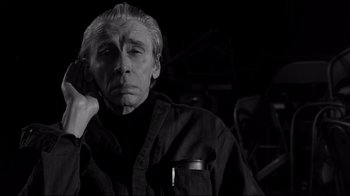 Movie still from “Coffee and Cigarettes” (2003), directed by Jim Jarmusch – An older man in a black shirt is looking at the camera; Close Up shot, Low angle