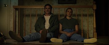 Movie still from “Cold in July” (2014), directed by Jim Mickle – A man and a woman sitting next to each other on a bench; Medium shot, Low angle