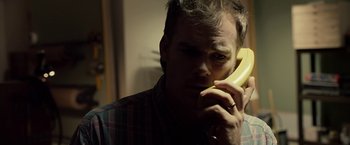 Movie still from “Cold in July” (2014), directed by Jim Mickle – A man talking on a phone while holding it to his ear; Close Up shot, Low angle