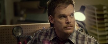 Movie still from “Cold in July” (2014), directed by Jim Mickle – A person wearing a plaid shirt; Close Up shot, Over the shoulder angle