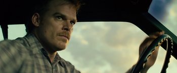 Movie still from “Cold in July” (2014), directed by Jim Mickle – A person in a car looking out the window; Close Up shot, Low angle