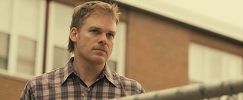 Movie still from “Cold in July” (2014), directed by Jim Mickle – A person wearing a plaid shirt; Close Up shot, Over the shoulder angle