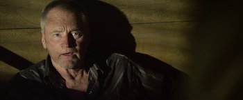 Movie still from “Cold in July” (2014), directed by Jim Mickle – A person wearing a striped shirt; Close Up shot, Low angle