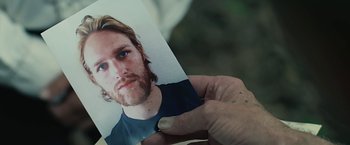 Movie still from “Cold in July” (2014), directed by Jim Mickle – A person holding a picture of a man; Extreme Close Up shot, Overhead angle