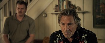 Movie still from “Cold in July” (2014), directed by Jim Mickle – A person sitting in a room; Close Up shot, Over the shoulder angle