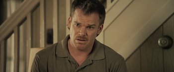 Movie still from “Cold in July” (2014), directed by Jim Mickle – A person wearing a green shirt; Close Up shot, Over the shoulder angle