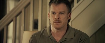 Movie still from “Cold in July” (2014), directed by Jim Mickle – A person wearing a shirt; Close Up shot, Over the shoulder angle