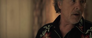 Movie still from “Cold in July” (2014), directed by Jim Mickle – A person wearing a black shirt; Close Up shot, Low angle