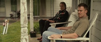 Movie still from “Cold in July” (2014), directed by Jim Mickle – A man sitting on a chair next to another man; Medium shot, Over the shoulder angle