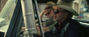 Movie still from “Cold in July” (2014), directed by Jim Mickle – A man in a cowboy hat sitting in the driver's seat of a car; Close Up shot, Low angle