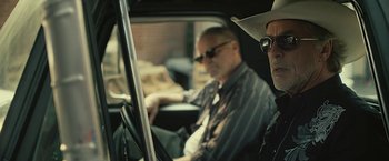 Movie still from “Cold in July” (2014), directed by Jim Mickle – Two men sitting in the drivers seat of a car; Close Up shot, Over the shoulder angle