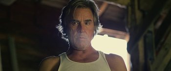 Movie still from “Cold in July” (2014), directed by Jim Mickle – A person wearing a white shirt; Close Up shot, Low angle