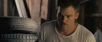 Movie still from “Cold in July” (2014), directed by Jim Mickle – A person wearing a white t - shirt; Close Up shot, Over the shoulder angle