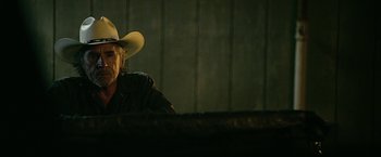 Movie still from “Cold in July” (2014), directed by Jim Mickle – A man wearing a cowboy hat sitting at a table; Close Up shot, Over the shoulder angle