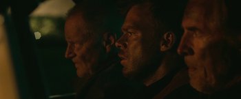 Movie still from “Cold in July” (2014), directed by Jim Mickle – Two men are looking into the distance in the dark; Close Up shot, Over the shoulder angle