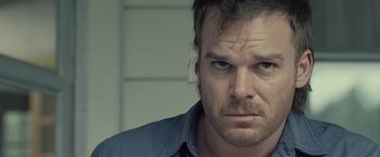 Movie still from “Cold in July” (2014), directed by Jim Mickle – A person wearing a blue shirt; Close Up shot, Over the shoulder angle
