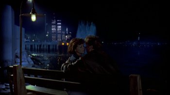 Movie still from “Coneheads” (1993), directed by Steve Barron – Two people sitting on a park bench at night; Wide shot, Over the shoulder angle