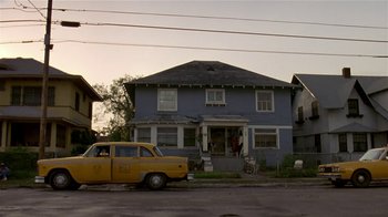 Movie still from “Coneheads” (1993), directed by Steve Barron – An old car parked in front of an old house; Extreme Wide shot, Low angle